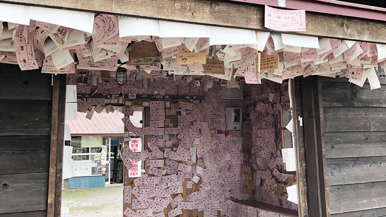 幸福駅の壁に願い事を書いた紙がたくさん貼られている。